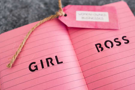 women-owned business tag with girl boss text on pink notepad, supporting equality and equal opportunitiesの写真素材