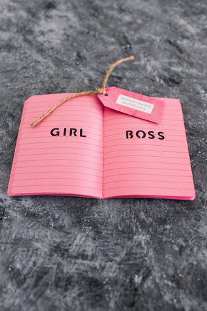 women-owned business tag with girl boss text on pink notepad, supporting equality and equal...