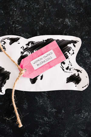 women-owned business tag over world map, supporting equality and equal opportunities globally