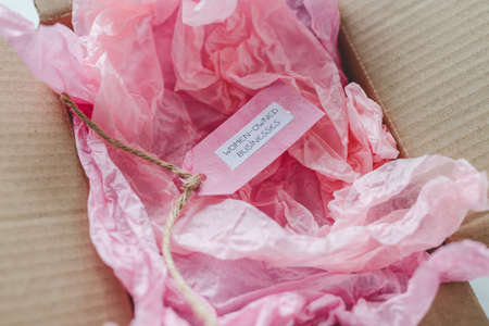 women-owned businesses tag inside online order delivery parcel, supporting equality and business...