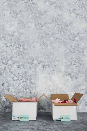 Cheap vs Costly product price tags in two delivery parcels next to each other symbol of options for...