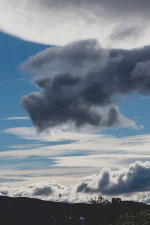 beautiful sky with clouds rolling over the mountains in Tasmania, Australia with contrasty tones