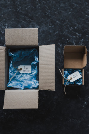 product tags with small business vs big brand texts inside of bigger and smaller delivery parcels,...