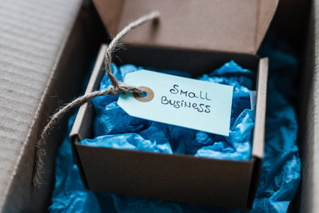 product tag with small business text inside ofsmaller delivery parcel inside of a bigger parcel,...