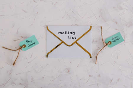 product tags with small business vs big brand texts over newsletter email envelopes, concept of customer behaviour and supporting small local businessesの写真素材