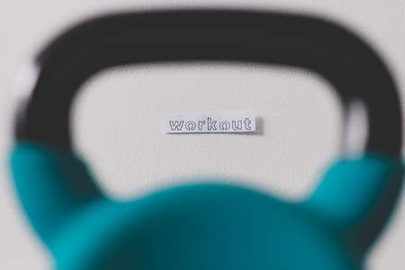 home gym and exercising in your spare time conceptual image, kettlebell on the floor with Workout messageの写真素材
