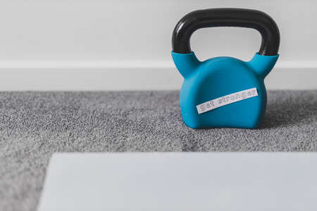 home gym and exercising in your spare time conceptual image, kettlebell and yoga mat on bedroom floor with Get Stronger messageの写真素材