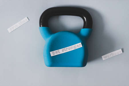 home gym and exercising in your spare time conceptual image, kettlebell and yoga mat on bedroom floor with Get Stronger messageの写真素材