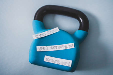 home gym and exercising in your spare time conceptual image, kettlebell with Gym Time Workout and Get Stronger message on yoga mat on bedroom floorの写真素材