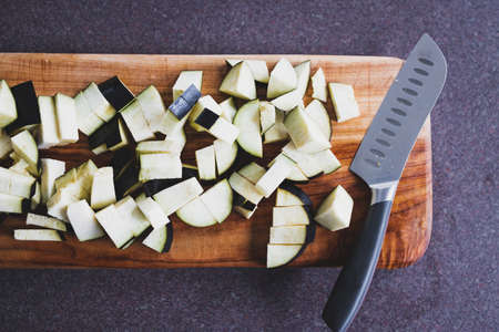 chopped eggplant cubes on cutting board, concept of simple natural healthy ingredientsの写真素材