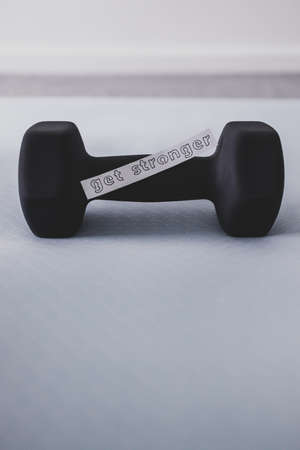home gym and exercising in your spare time, dumbbell on yoga mat on bedroom floor with Get Stronger...