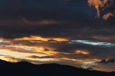 sunset sky with pink and orange clouds over the mountains shot in Tasmania, Australia in winter