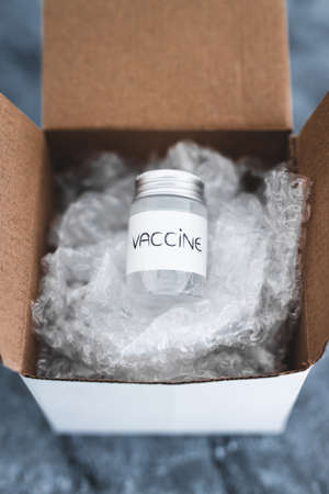 vaccine supply and eligibility in different countries conceptual image, vaccine vial inside of...