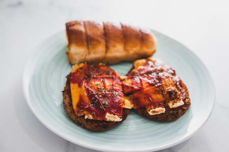 vegan chicken parmi with plant-based schnitzel topped with dairy-free cheese and tomato sauce and a side of garlic bread, healthy plant-based food recipesの写真素材