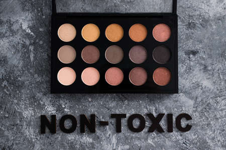 low tox and natural beauty products conceptual image, make-up palette with non-toxic text on grey backgroundの写真素材