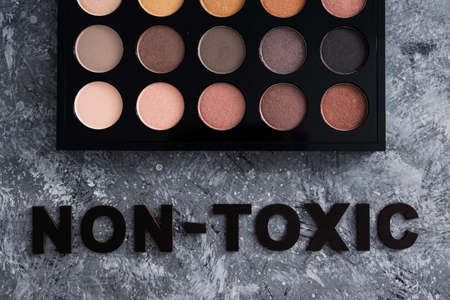 low tox and natural beauty products conceptual image, make-up palette with non-toxic text on grey backgroundの写真素材