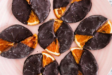 dehydrated orange slices covered in dark chocolate, healthy plant-based sweetsの写真素材