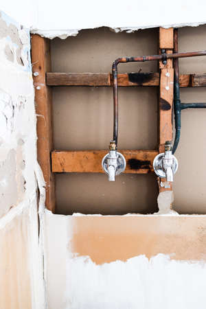 laundry room renovation with plaser walls interior exposed with taps and copper pipes, concept of home renovations and tradesman workの写真素材