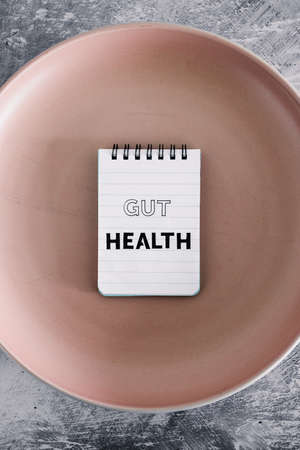 gut health text on notepads on top of dining plate, concept of healthy nutrition and scientific...