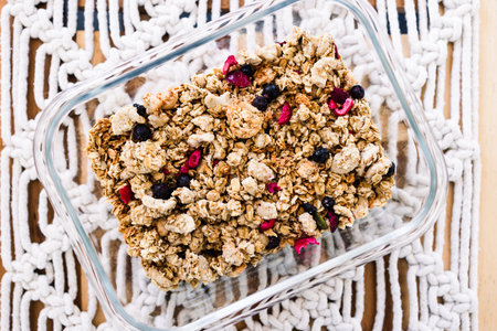 vegan homemade granola with oats grains and dried fruits in glass lunch box, healthy plant-based food recipesの写真素材
