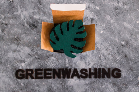 greenwashing and companies pretending to be sustainable conceptual image, paper leaf on product packaging with textの写真素材