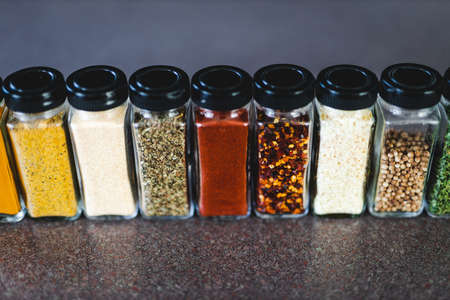 spices seeds and seasonings in matching spice jars on tidy pantry shelf, simple vegan ingredients and concept of flavoring your dishesの写真素材