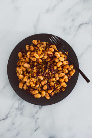 vegan sauted cauliflower rice and butter beans with sundried tomatoes and herbs, healthy plant-based food recipesの写真素材