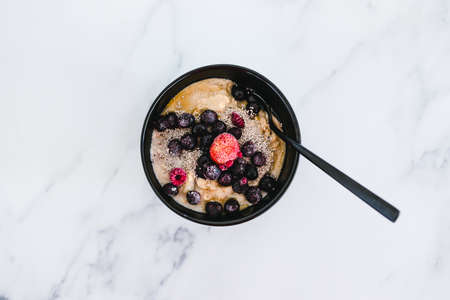 vegan oatmeal with soy milk topped with berries and chia seeds, healthy plant-based food recipes
