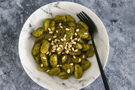 vegan avocado basil pesto gnocchi with pine nuts topping, healthy plant-based food recipesの写真素材