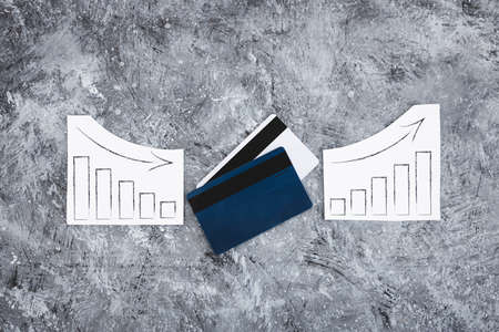 financial markets or money and investments conceptual image, payment cards with charts showing upward and downward trendsの写真素材