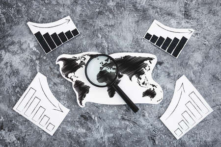 financial markets or money and investments conceptual image, world map symbol of global markets with charts showing upward and downward trendsの写真素材