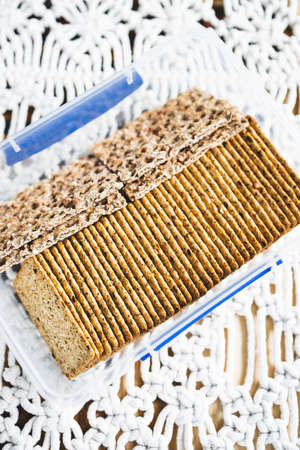 airtight container with multigrain and multiseeds crackers in tidy lines, concept of simple natural healthy ingredients and organising your pantryの写真素材