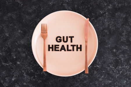 gut health text on dining plate with fork and knife, healthy nutrition and scientific research about the microbiomeの写真素材