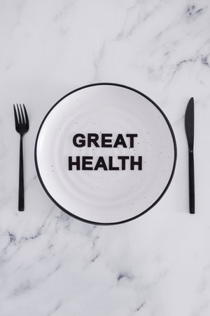 great health text on dining plate with fork and knife, concept of dieting vs healthy nutrition and intuitive eatingの写真素材