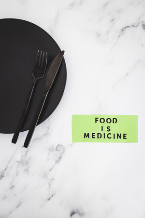 Food is Medicine text on dining plate with fork and knife, concept of dieting vs healthy nutrition and intuitive eatingの写真素材