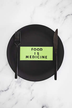 Food is Medicine text on dining plate with fork and knife, concept of dieting vs healthy nutrition and intuitive eatingの写真素材
