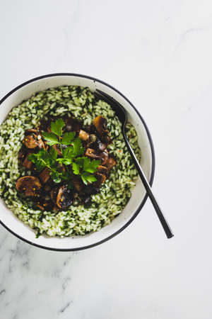 vegan risotto with fresh mushrroms and spinach, healthy plant-based food recipesの写真素材