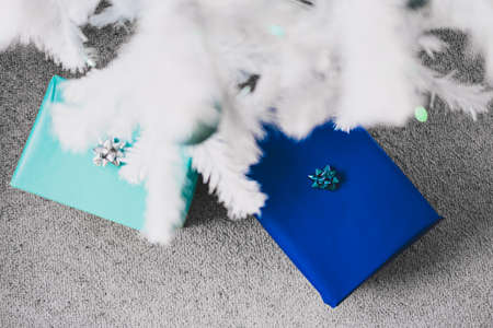 christmas tree with white frosted snow style and blue and teal toned presents and baubles shot at...