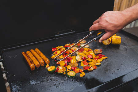 vegan barbecue with grilled vegetables plant-based sausages and corn on the cob, healthy plant-based food recipesの写真素材
