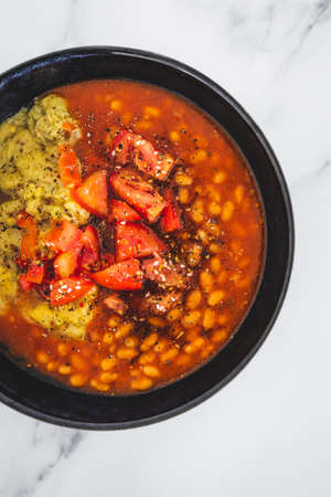 vegan baked beans and chickpea flour frittata with tomato salsa topping, healthy plant-based food...
