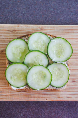 sliced cucumber sandwich with vegan mayo on cutting board, concept of simple natural healthy ingredientsの写真素材