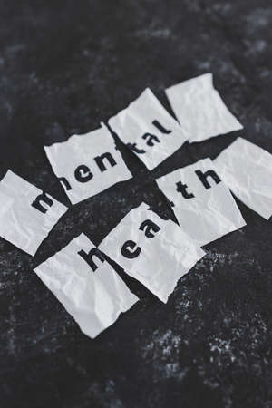 Mental health text on crumpled and torn piece of paper which has been reassembled, concept of psychology and emotional healingの写真素材
