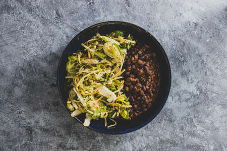 vegan nourish bowl with black beans and mixed greens, healthy plant-based food recipes