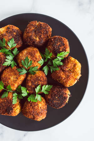 vegan pesto arancini fried risotto balls with fresh parsley as topping, healthy plant-based food recipesの写真素材