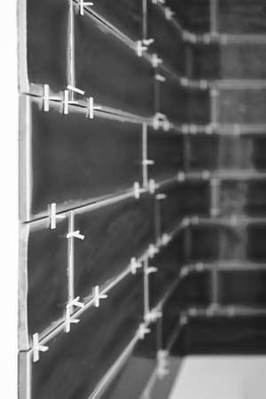 ceramic tiles being laid on laundry splashback with spacers, concept of diy and home improvementの写真素材