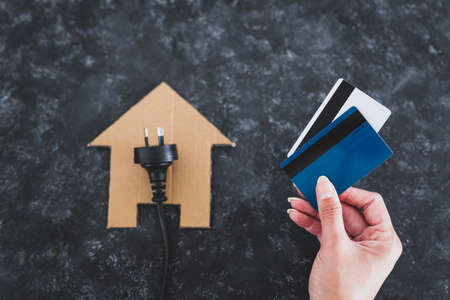 house icon on black with Australian plug on it and payment cards next to it, concept of electricity bill and power companiesの写真素材