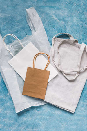 single use plastic bag next to paper and reusable canvas ones, plastic pollution and environmental awareness conceptの写真素材