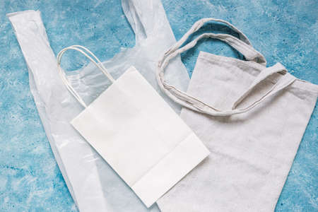 single use plastic bag next to paper and reusable canvas ones, plastic pollution and environmental awareness conceptの写真素材