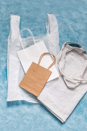 single use plastic bag next to paper and reusable canvas ones, plastic pollution and environmental awareness conceptの写真素材