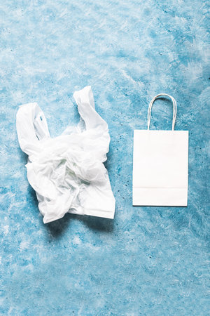 single use plastic bag next to paper one, plastic pollution and environmental awareness concept